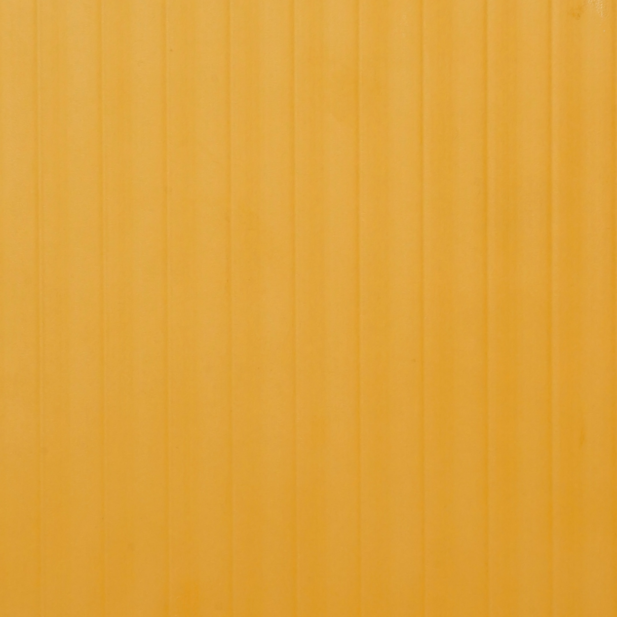 PL-202 Amber Groove laminate with vibrant amber-orange tone and vertical woodgrain grooves for bold, lively interiors by Plyneer.